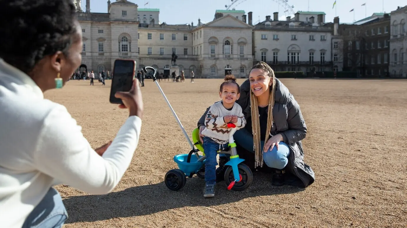 Seitenansicht einer Frau, die mit dem Handy Fotos macht.