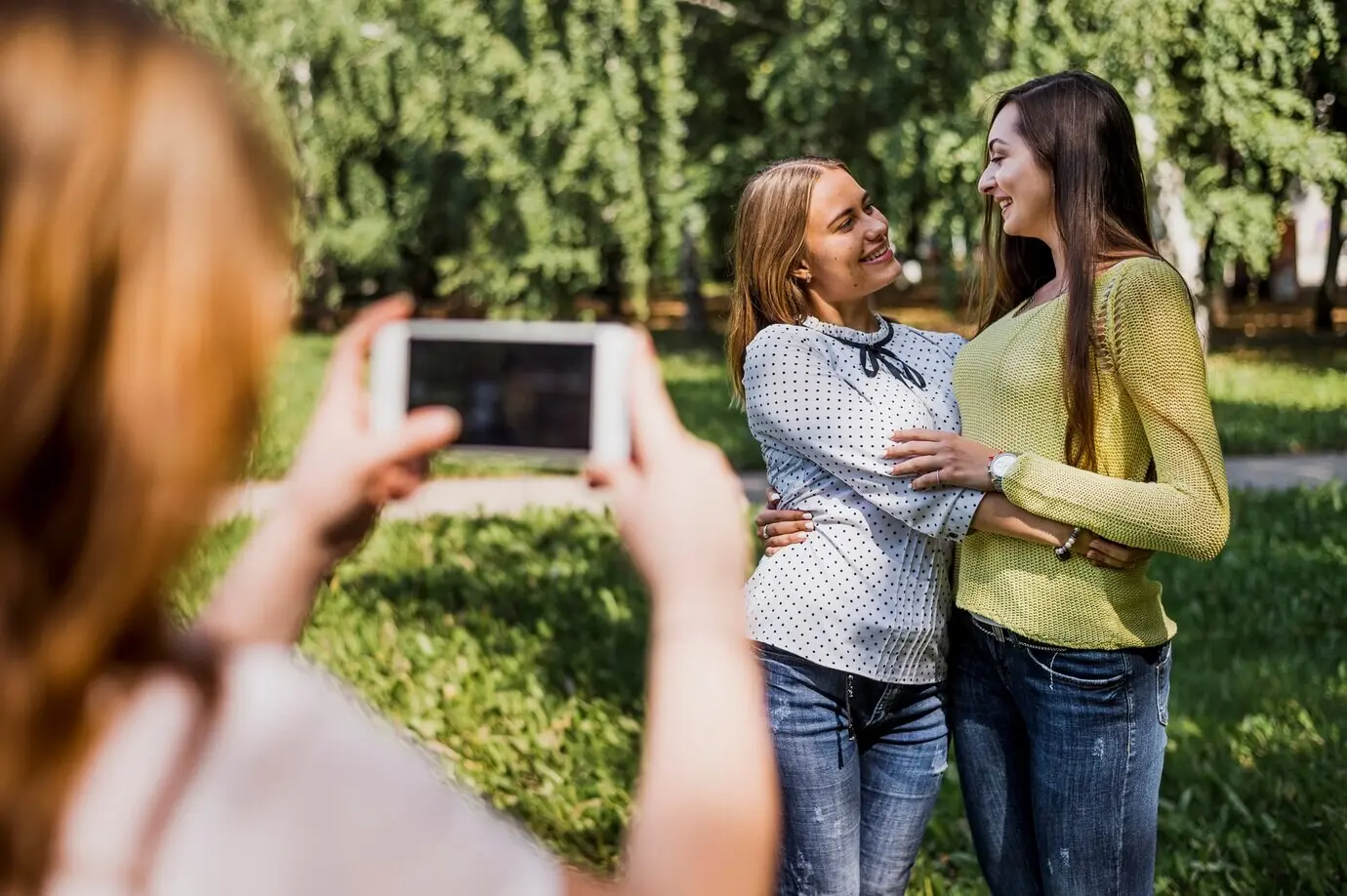 Teenagerinnen fotografieren sich gegenseitig.